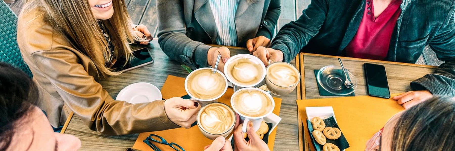Top-view-of-happy-friends-toasting-cappuccino-drin-